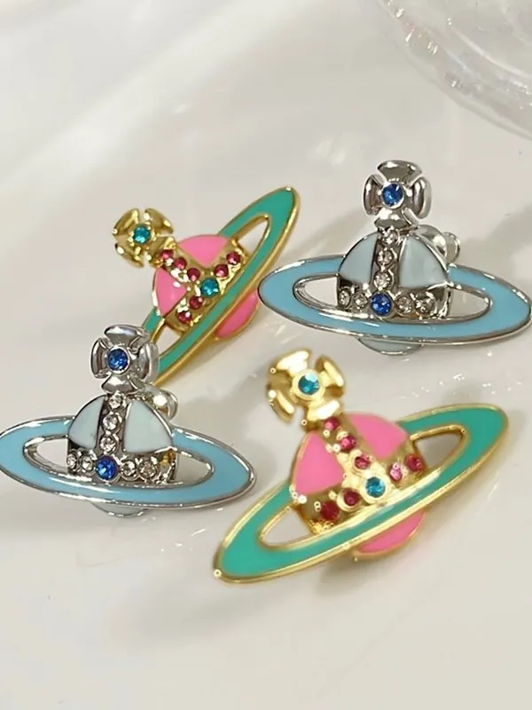 Aretes con dije de Saturno con diamantes de imitación esmaltados